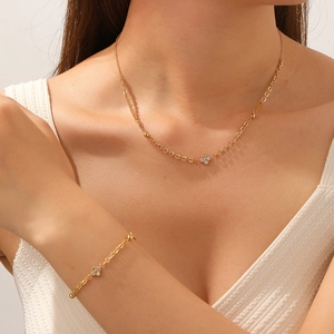 Elegant gold clover jewelry set with sparkling rhinestones worn by a fashion model