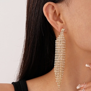 Gros plan de boucles d'oreilles pendantes dorées à franges et strass étincelants