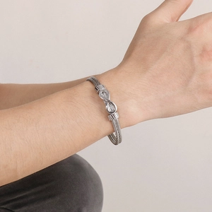 Titanium steel braided cable bracelet featuring a silver infinity charm on wrist