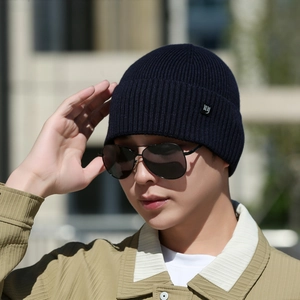 Bonnet en maille côtelée bleu marine avec écusson 'ny' porté par un mannequin homme
