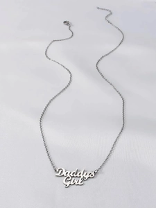 Detailed close-up of Daddy's Girl silver stainless steel pendant on white fabric background