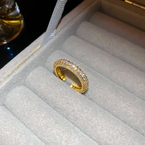 Macro shot of three-row zircon-inlaid gold-plated twist ring with adjustable open band