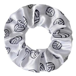 Détail d'un chouchou en satin blanc avec motifs de volleyball noirs et texture soyeuse