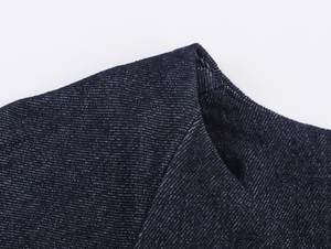 Detailaufnahme der hochwertigen dunkelblauen Denim-Stoffstruktur mit weißer Sprenkelung
