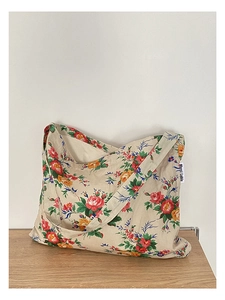 Detailed view of beige canvas tote bag with vintage floral print and wide strap design