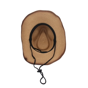 Détail d'un chapeau de cowboy en paille tressée avec cordon réglable et fini texturé