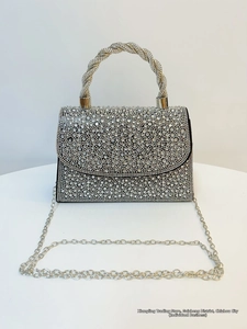 Macro shot of silver rhinestone handbag with sparkling crystal handle and chain strap