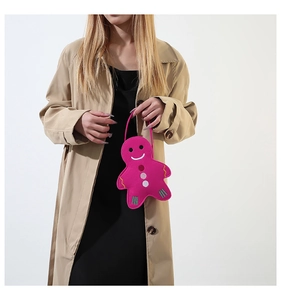 Détail d'un sac en feutre bonhomme pain d'épice rose porté par un mannequin en manteau