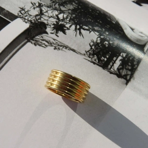 Polierter 18K vergoldeter breiter Mehrlagenring auf einer kunstvollen Magazinseite