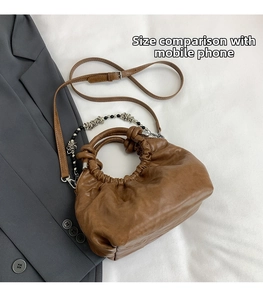 Detail of brown pleated leather cloud bag with silver hardware and bead chain decor