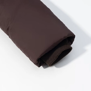 Detail of windproof brown puffer jacket sleeve with inner ribbed knitted cuffs