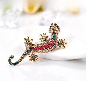 Macro shot of lizard brooch with colorful rhinestones on a gold alloy base