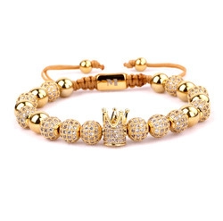 Macro detail of gold crown bracelet featuring micro-pave zircons and adjustable cord
