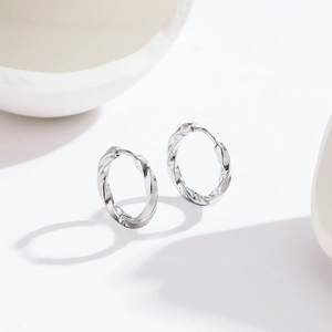 Minimalist silver twisted titanium steel hoop earrings featuring elegant spiral texture
