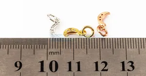 Close-up of crescent moon pendants with cubic zirconia in gold, silver, and rose gold finishes