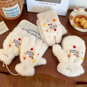 Winter plush mittens with cartoon dog design and colorful pom-poms on wooden desk