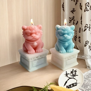 Detail of lit cat-shaped candles in pink and blue with elegant relief base and bells