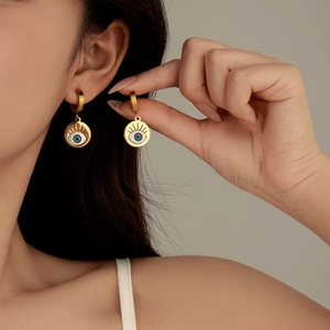 Exquisite gold Evil Eye dangle earrings with blue and white zircon stones on model