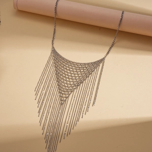Détail du collier triangle en maille argentée avec longues franges métalliques sur support