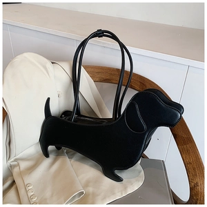 Detail of creative black dachshund-shaped leather shoulder bag placed on a wooden chair