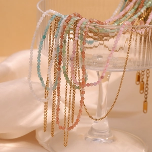 Detail of 18K gold plated layered necklace with colorful amazonite beads on glass