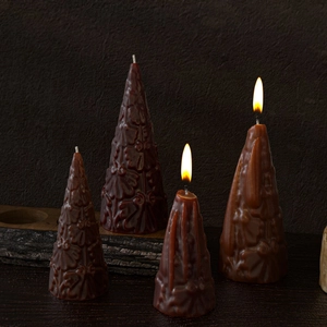 Detailed relief flower patterns on cone-shaped brown scented candles with a wooden base