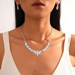 Close-up of elegant silver necklace and teardrop earrings with sparkling zircons