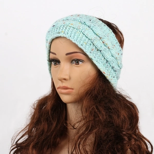 Detail of cable knit headband in mint green with colorful specks on a head model