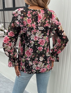 Detail view of floral print blouse featuring ruffled sleeves and a teardrop back cutout