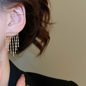 Close-up of elegant gold multi-row tassel earrings with cascading metal bead chains