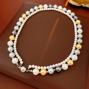 Détail d'un collier de perles double couche avec des perles multicolores et un fermoir aimanté