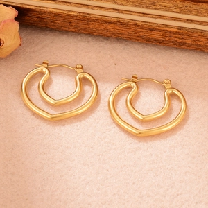 Détail des boucles d'oreilles doubles en forme de cœur doré avec finition texturée