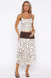 Detailed view of the polka dot crop top and matching midi skirt with a wide waistband