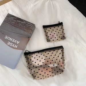 Transparent mesh makeup bag set with heart print and zipper on white fabric background