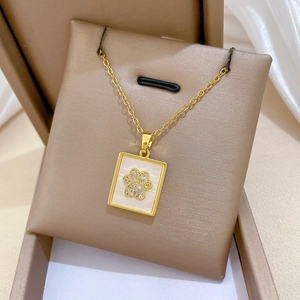Macro detail of gold cat paw necklace with white shell inlay and sparkling crystals