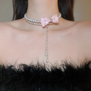 Detail of pink bow choker with pearls and rhinestones on neck for balletcore style