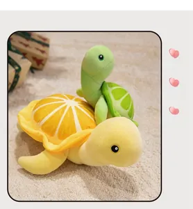 Détail de la grande peluche tortue jaune à motif orange et de la petite tortue verte