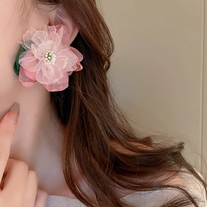 Elegant floral stud earrings with pink lace petals and green leaf on female model