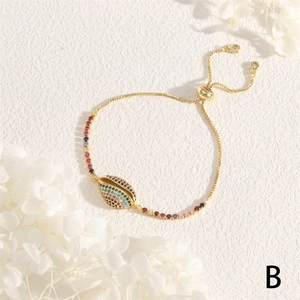 Detail of adjustable gold shell bracelet with colorful micro-set zircons and slide clasp