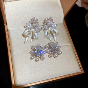 Detailed view of 14k gold plated pearl and zircon floral earrings in a jewelry box