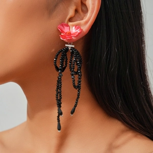 Pink flower earrings with black beaded tassels on a model, vintage retro style jewelry
