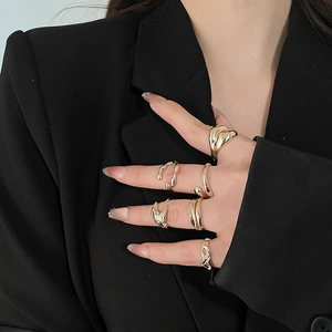 Detailed view of irregular liquid metal gold rings set on model with black suit