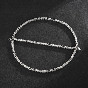 Macro shot of silver Byzantine chain necklace with lobster clasp on black background