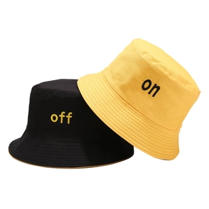 Bobs en coton noir et jaune avec broderies 'on' et 'off' sur fond blanc pur et épuré