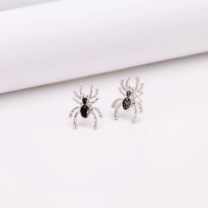 Dettaglio di orecchini a lobo a forma di ragno argento con smalto nero e gambe texture