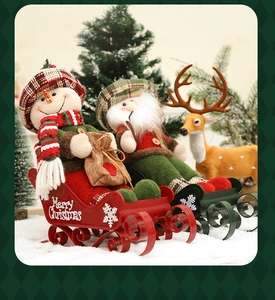 Detailed view of plush snowman and Santa figurines on a sleigh in a festive snowy scene