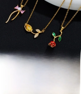 Detail of gold-plated tulip and rose necklace with pink bow and pearl pendant