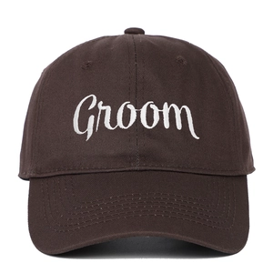 Close-up of white Groom embroidery on a dark brown cotton baseball cap for weddings