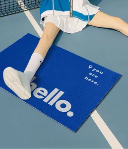 Detail of blue rectangular entryway rug with white hello text in a tennis court setting