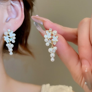 Elegant gold flower earrings with white shell petals, pearls and crystals tassels